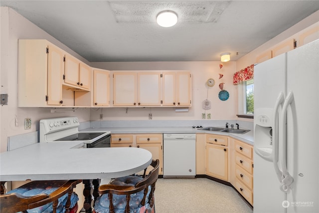 kitchen with kitchen peninsula, white appliances, cream cabinetry, a textured ceiling, and sink