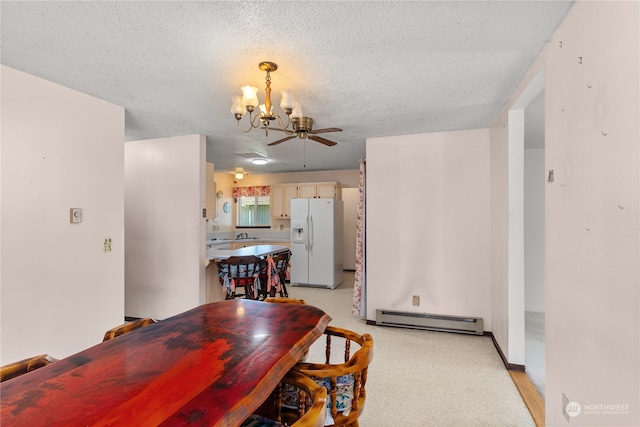 dining room with ceiling fan with notable chandelier, a baseboard heating unit, and a textured ceiling