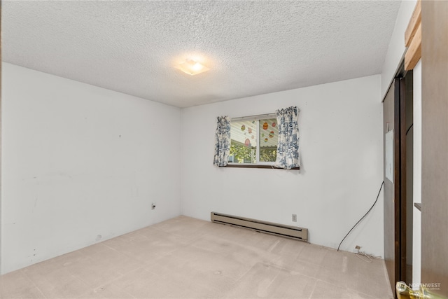 carpeted spare room with baseboard heating and a textured ceiling