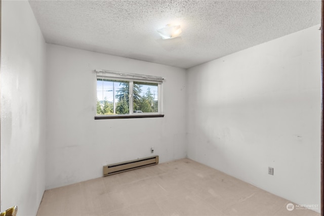 unfurnished room with light colored carpet, a baseboard heating unit, and a textured ceiling