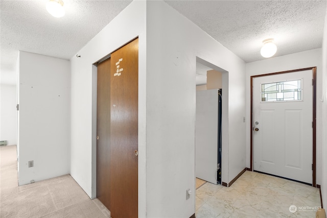 carpeted entryway with a textured ceiling