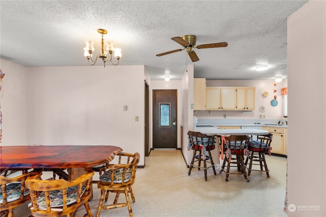 dining area featuring ceiling fan with notable chandelier and a textured ceiling