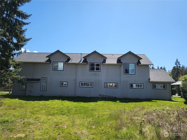 rear view of property featuring a lawn