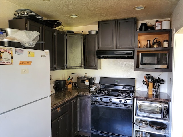 kitchen with white fridge, a textured ceiling, range hood, gas range oven, and stainless steel microwave