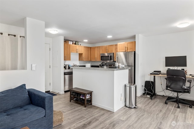 kitchen featuring light brown cabinetry, stainless steel appliances, and light wood-type flooring