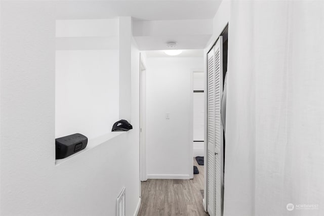 hallway with light hardwood / wood-style floors