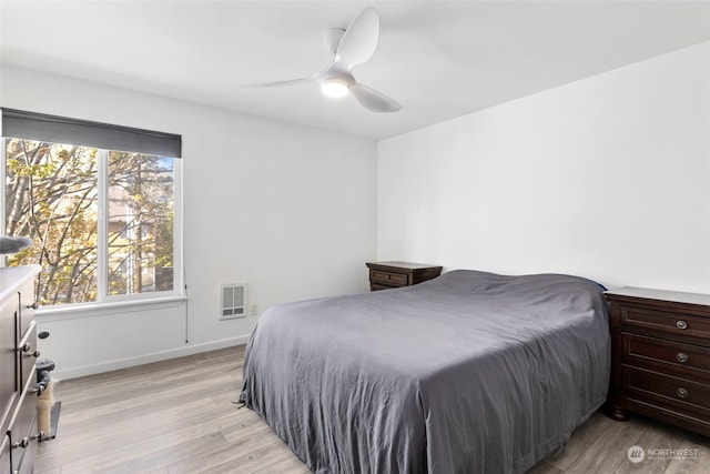 bedroom featuring light hardwood / wood-style floors, ceiling fan, and multiple windows