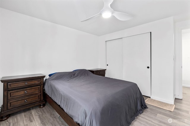 bedroom featuring light hardwood / wood-style flooring, ceiling fan, and a closet