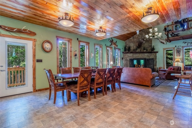 dining area featuring wooden ceiling, plenty of natural light, light tile floors, and a fireplace