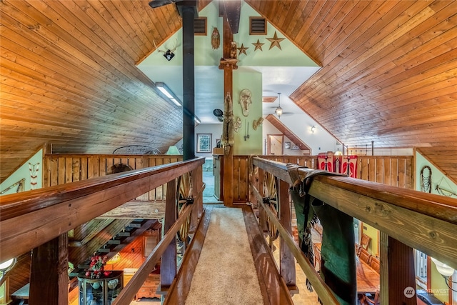 interior space featuring wooden ceiling, lofted ceiling, carpet, and wooden walls