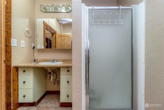 bathroom with tile flooring, sink, and walk in shower