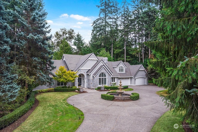 view of front of property featuring a garage and a front lawn