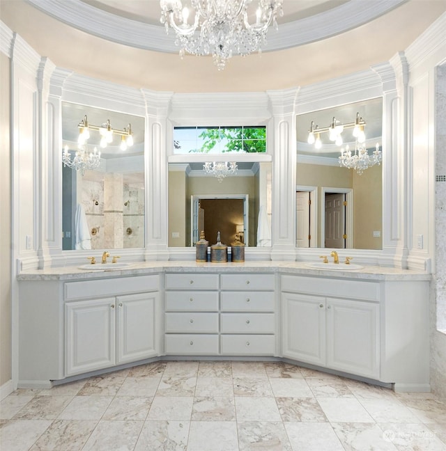 bathroom with an inviting chandelier, vanity, crown molding, and ornate columns