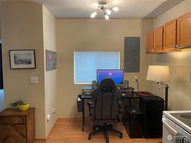 office space featuring an inviting chandelier, light hardwood / wood-style flooring, and electric panel