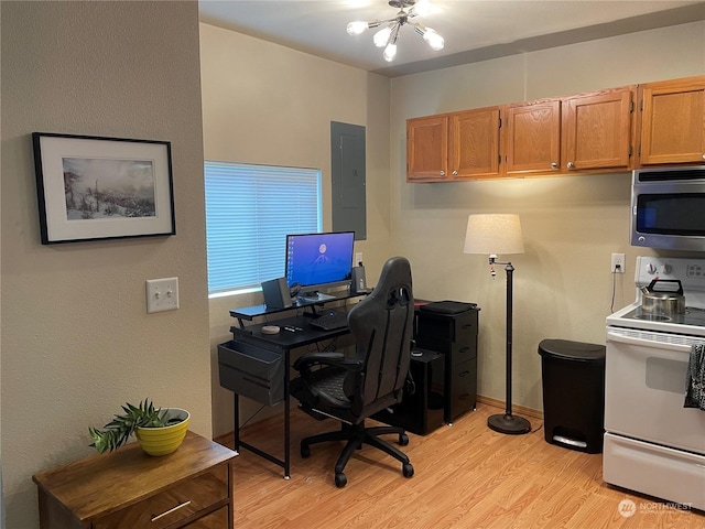 home office featuring an inviting chandelier, electric panel, and light hardwood / wood-style floors