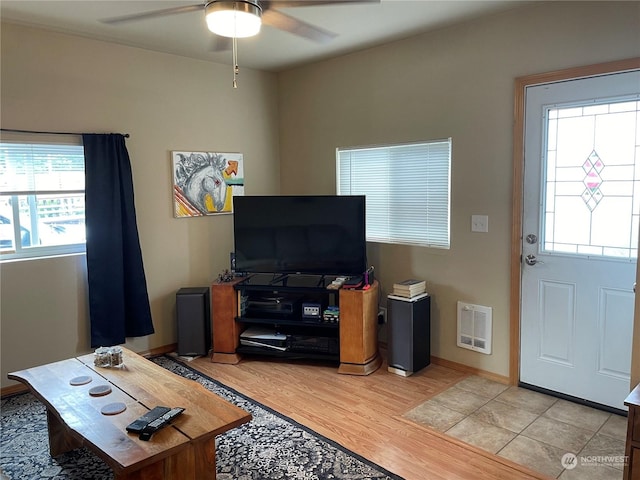 living room with ceiling fan, plenty of natural light, and light wood-type flooring