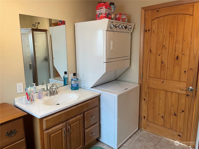 laundry room featuring sink, light tile patterned floors, and stacked washing maching and dryer