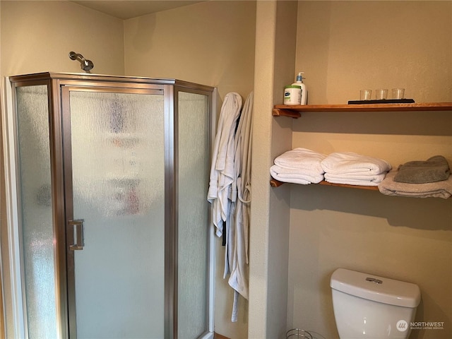 bathroom with toilet and a shower with door