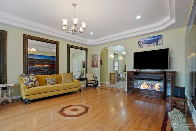 living room with a chandelier, wood-type flooring, and a tray ceiling