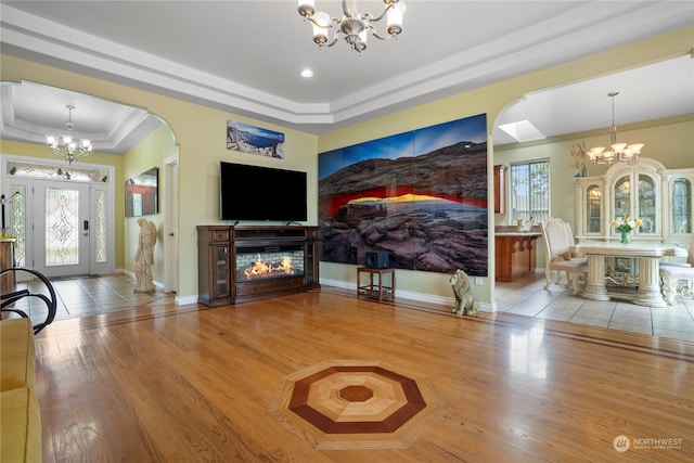 interior space featuring a raised ceiling, ornamental molding, light wood-type flooring, and a wealth of natural light