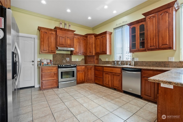 kitchen featuring appliances with stainless steel finishes, crown molding, sink, and light tile patterned floors