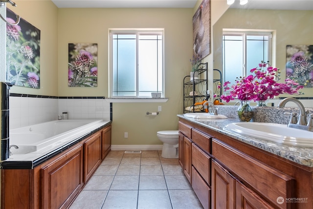 bathroom with vanity, toilet, a tub to relax in, and tile patterned floors