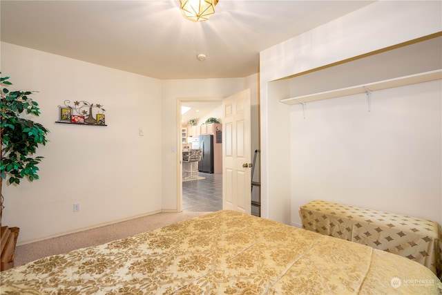 carpeted bedroom with stainless steel refrigerator