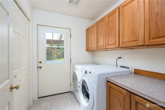 laundry room with hookup for a washing machine, washing machine and clothes dryer, cabinets, and light tile flooring