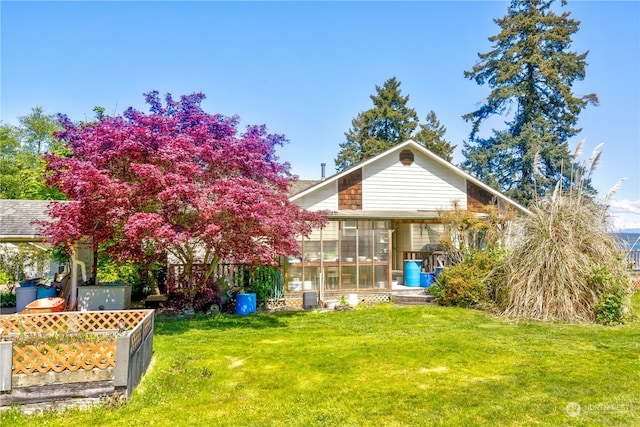 back of house featuring a yard, central air condition unit, and a sunroom