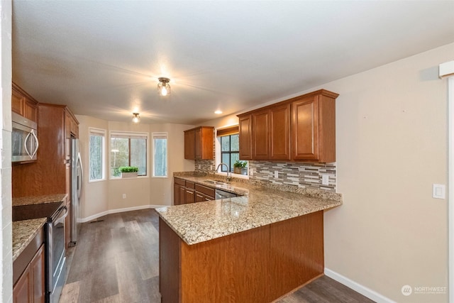 kitchen featuring kitchen peninsula, appliances with stainless steel finishes, and a wealth of natural light