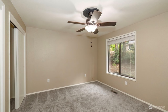 unfurnished bedroom featuring carpet flooring, ceiling fan, and a closet