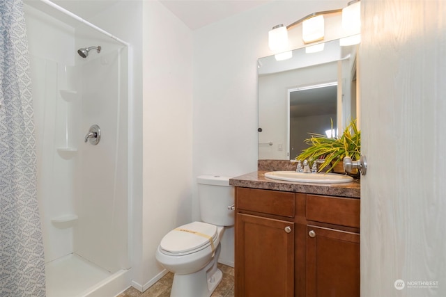 bathroom featuring a shower, vanity, and toilet