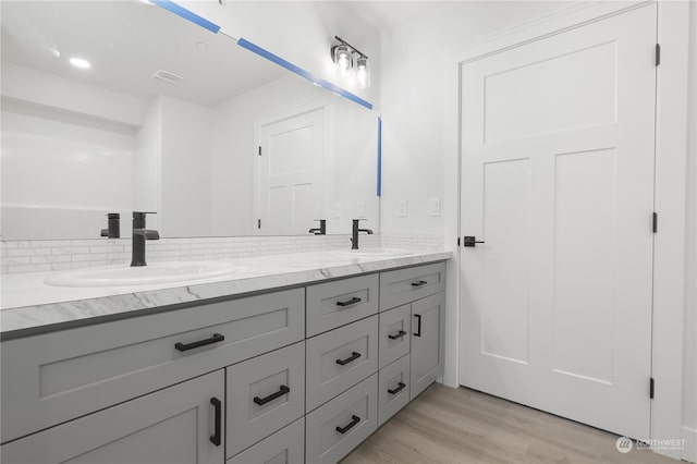 bathroom featuring backsplash, vanity, and wood-type flooring