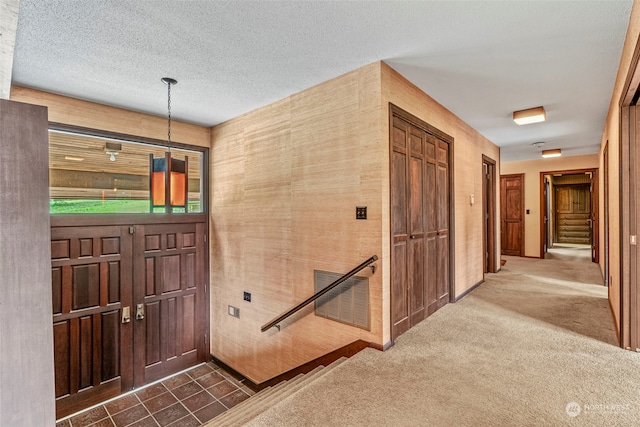 foyer entrance with a textured ceiling and tile floors