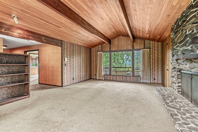 unfurnished living room with a stone fireplace, carpet, vaulted ceiling with beams, and wooden ceiling