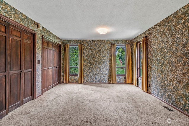 unfurnished bedroom featuring carpet flooring and a textured ceiling