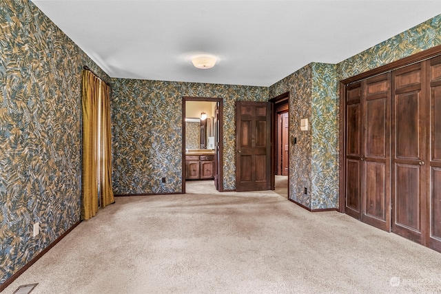 interior space with light colored carpet and ensuite bath