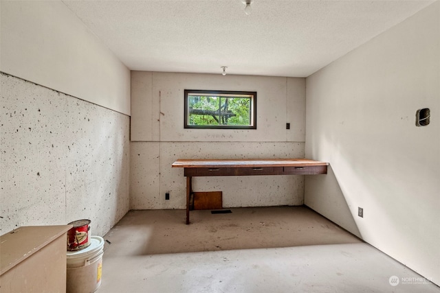 misc room featuring concrete flooring and a textured ceiling