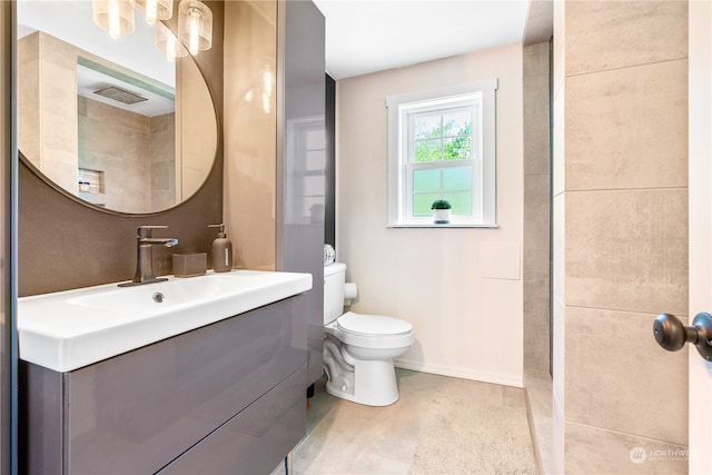 bathroom featuring tile floors, vanity with extensive cabinet space, and toilet