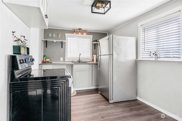 kitchen with white cabinets, stainless steel fridge, hardwood / wood-style flooring, and electric range oven