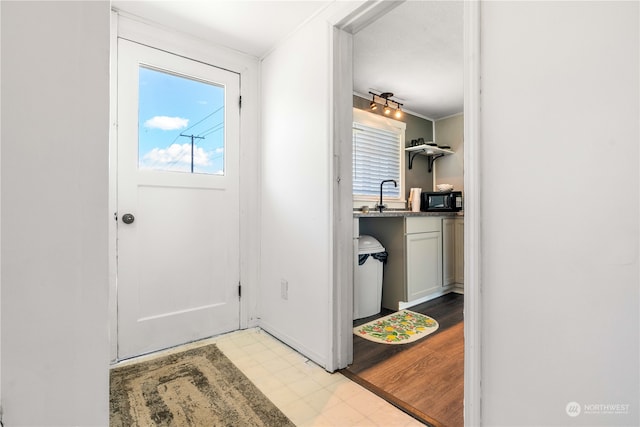 doorway featuring light tile floors and ornamental molding