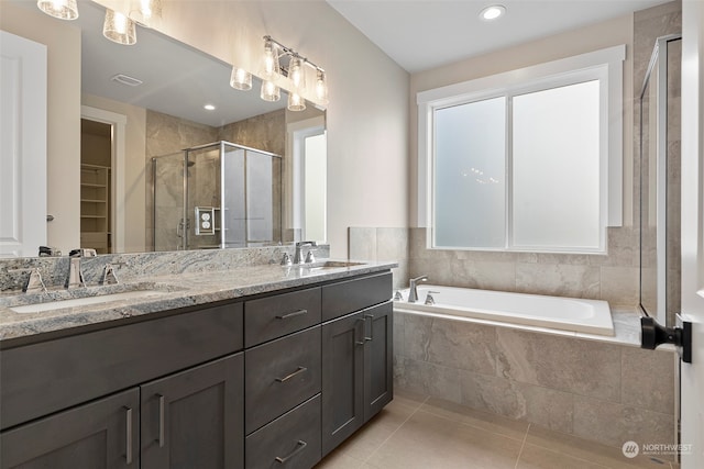 bathroom with plus walk in shower, tile patterned flooring, and vanity