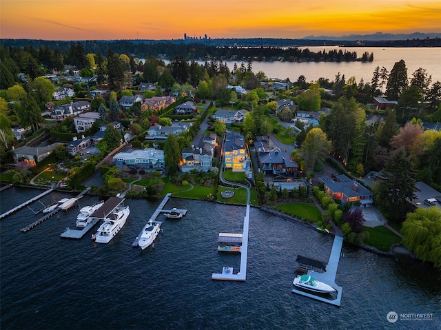 aerial view at dusk featuring a water view