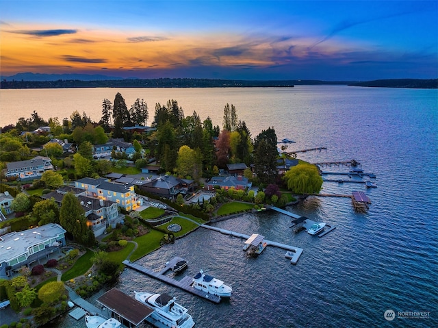 aerial view at dusk featuring a water view