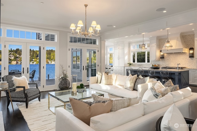 living room featuring a wealth of natural light, wood-type flooring, a water view, and french doors