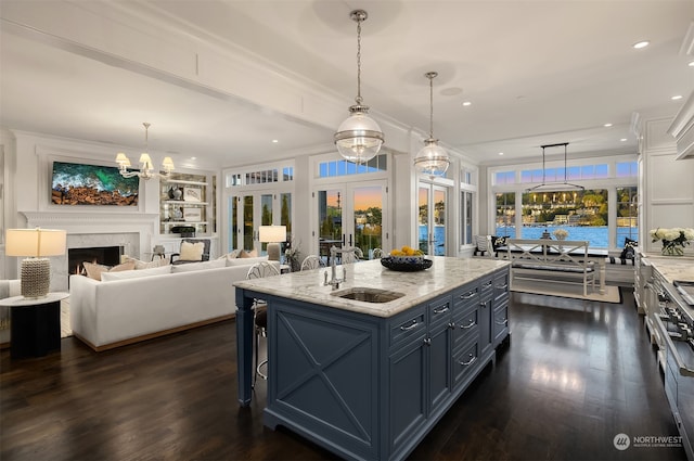 kitchen featuring a center island, hanging light fixtures, dark wood-type flooring, and a high end fireplace