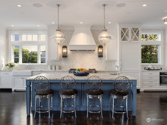 kitchen featuring backsplash, dark hardwood / wood-style flooring, a center island, and premium range hood