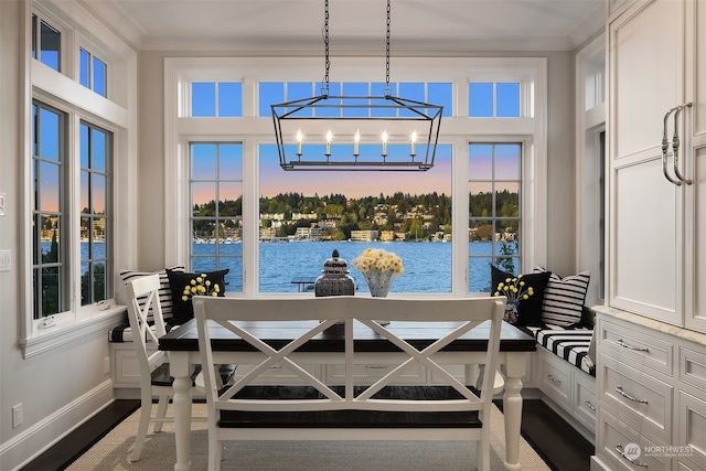 dining room featuring a wealth of natural light, a water view, and a chandelier