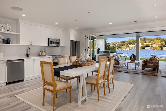 dining area with light hardwood / wood-style floors and sink