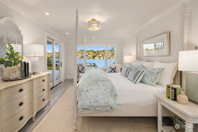 bedroom with a water view, ornamental molding, hardwood / wood-style flooring, and access to exterior